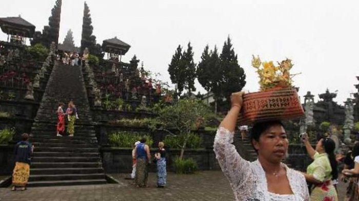 Umat Hindu usai sembahyang di Pura Besakih, Kecamatan Rendang, Karangasem, Bali. Pura terbesar di Bali yang mengalami perkembangan sejak masa pra-hindu, ini berorientasi ke Gunung Agung yang dianggap sebagai tempat tinggal para dewata.