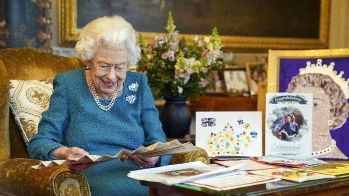 Sebuah gambar yang dirilis pada 4 Februari 2022, dan diambil bulan lalu, menunjukkan Ratu Elizabeth II dari Inggris melihat ke kipas Autograph Ratu Victoria, di samping pajangan memorabilia dari Golden dan Platinum Jubilees-nya, di Oak Room di Windsor Castle, sebelah barat London.