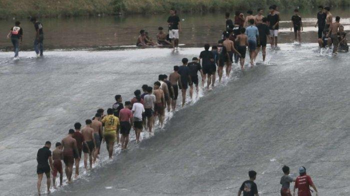 Pemandangan banyaknya anak-anak dan remaja yang main seluncuran di pintu air bendungan Pleret Banjirkanal Barat (BKB) Kota Semarang, baru-baru ini.