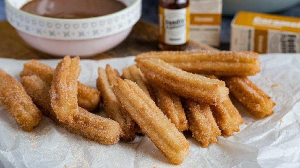 Piring churros yang siap disajikan dengan saus cokelat
