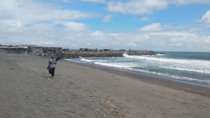 Seorang pemancing berjalan di tepian Pantai Glagah, Kecamatan Temon, Kulon Progo, belum lama ini.