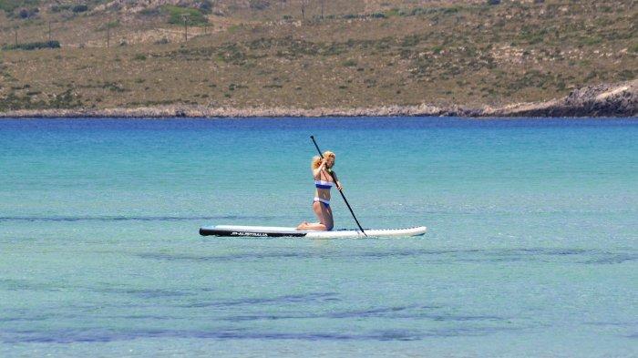 Seorang wanita melakukan paddleboarding.