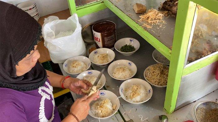 Proses penyajian Soto Ayam Pak Trimo dengan isian yang terdiri dari nasi, soun, tauge, ayam suwir, perkedel, dan tahu bacem, Jumat (23/9/2022).