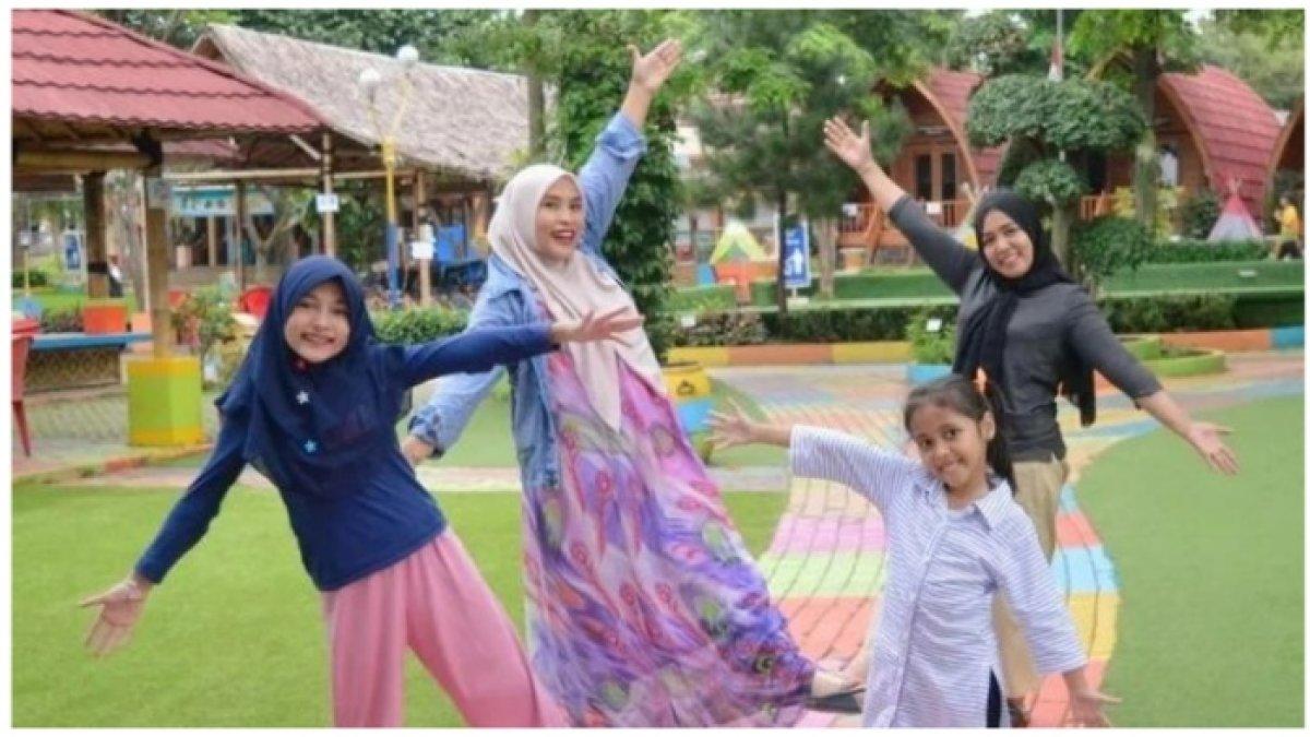 Pengunjung berpose di tempat wisata Taman Herbal Insani Depok, simak harga tiket masuk terbarunya.