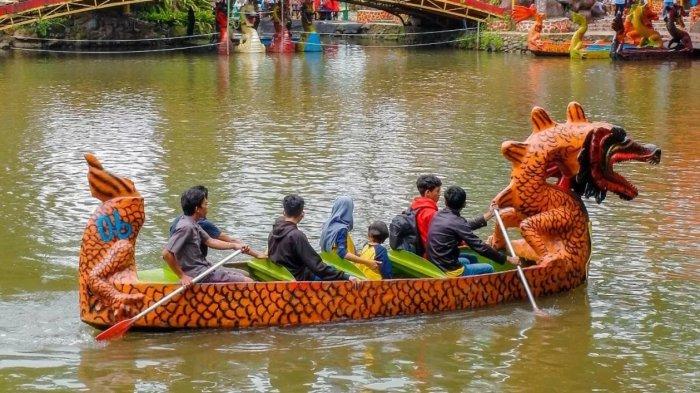 Pengunjung sedang berkeliling naik perahu di Taman Wisata Matahari.