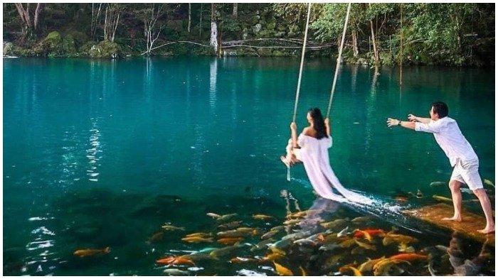 Wisatawan bermain ayunan di Telaga Biru Cicerem