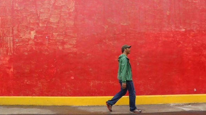Wisatawan melewati tembok rumah merah atau juga dikenal dengan sebutan Tiongkok Kecil Heritage di Desa Karangturi, Kecamatan Lasem, Kabupaten Rembang, Jawa Tengah.