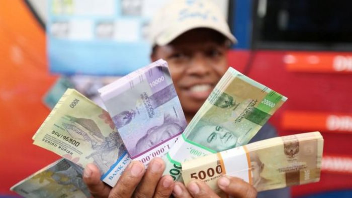 Warga menunjukkan mata uang rupiah Negara Kesatuan Republik Indonesia (NKRI) tahun emisi 2016 di lokasi penukaran uang di Blok M Square, Jakarta, Senin (19/12/2016). Bank Indonesia resmi meluncurkan uang NKRI tahun emisi 2016 dengan menampilkan 12 pahlawan nasional yakni 7 uang rupiah kertas dan dan 4 uang rupiah logam.