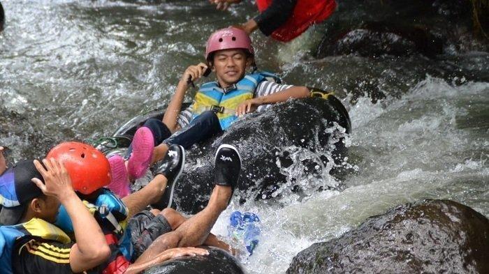 Ilustrasi wisatawan saat menikmati wahana wisata river tubing.