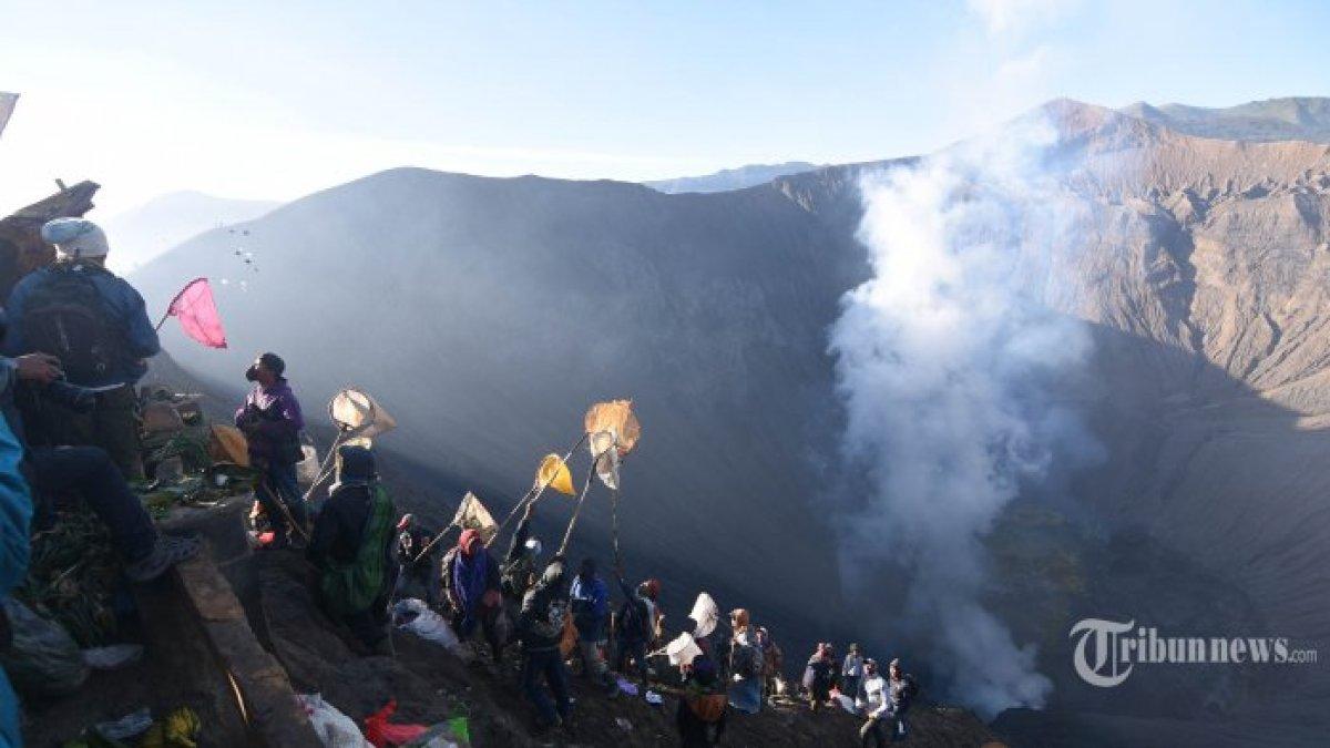 Sejumlah warga menunggu sesaji yang akan dilarung oleh warga suku Tengger di kawah Gunung Bromo saat Upacara Yadnya Kasada, Senin (10/7/2022).