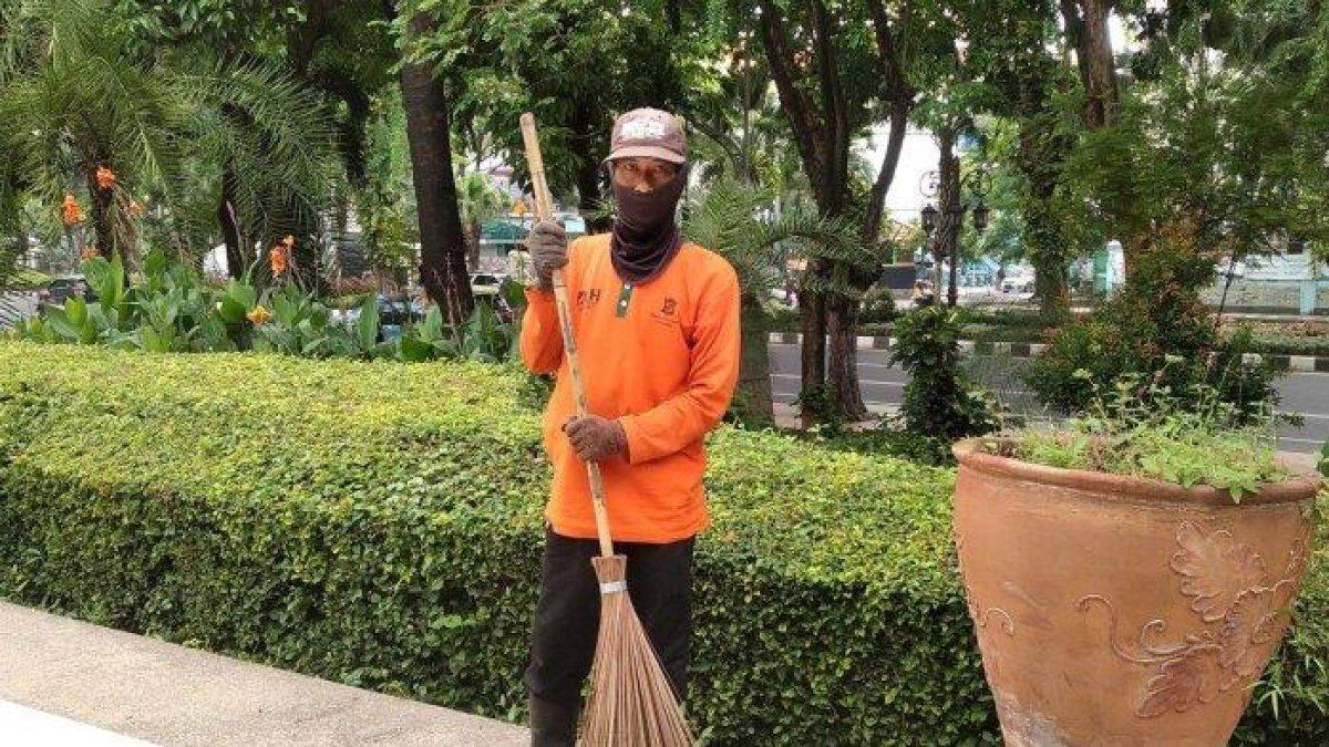 Budi Santoso seorang tukang sapu jalanan di Kota Surabaya, Sabtu (25/1/2025). Ia mencuri perhatian karena sempat jadi pegawai BUMN.