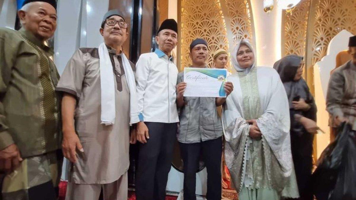Baharuddin (43) bersama pengurus Masjid Babussa'adah saat mendapatkan sertifikat umrah gratis, Senin (25/3/2023) malam