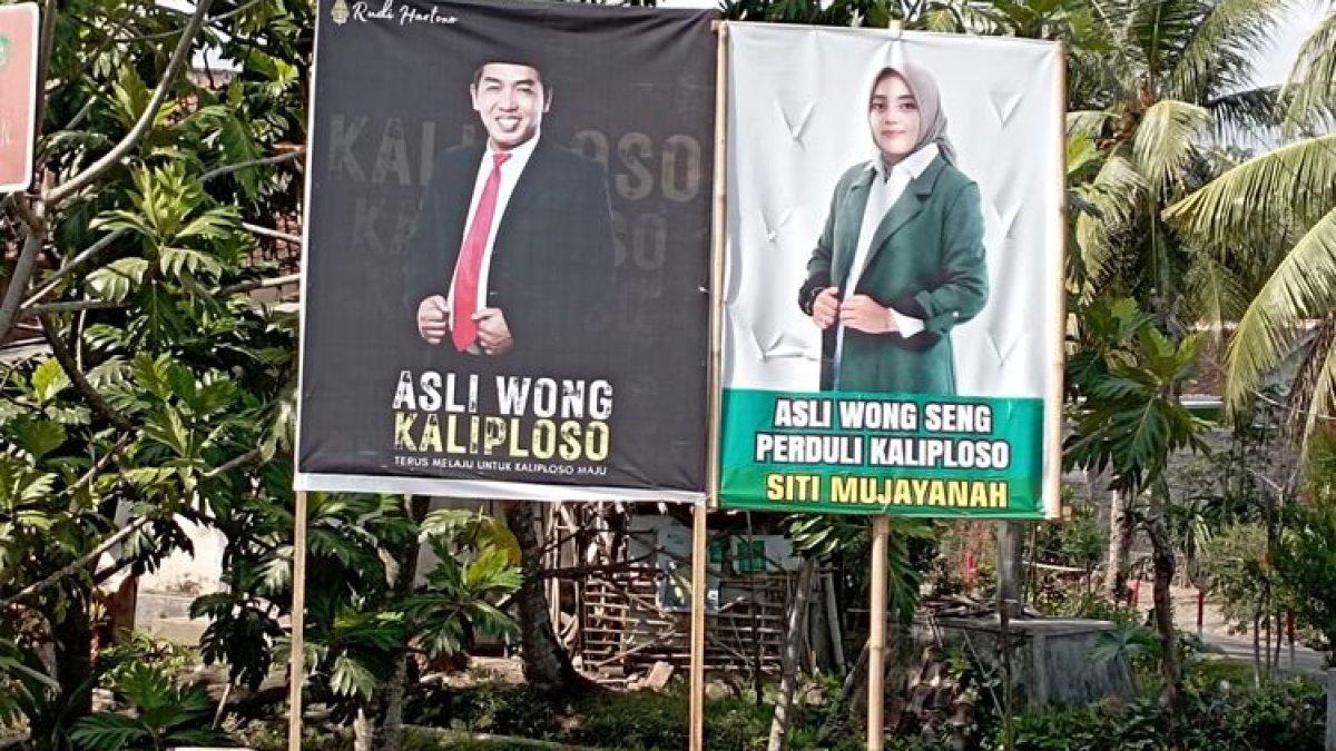 Banner mantan pasangan suami istri yang bertarung di Pilkades Desa Kaliploso pada Pilkades serentak Banyuwangi, Jawa Timur, Rabu (25/10/2023). (Kompas.com/Rizki Alfian Restiawan)