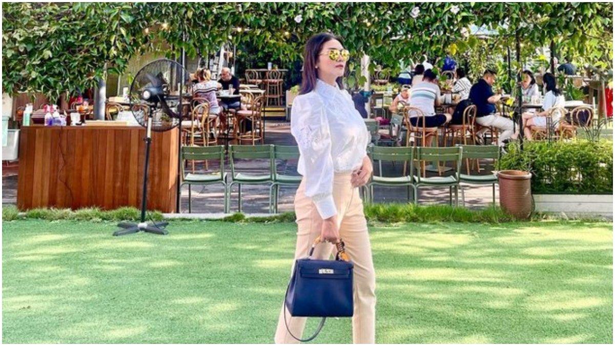 Bella Saphira menenteng tas bewarna ungu saat di Singapura.