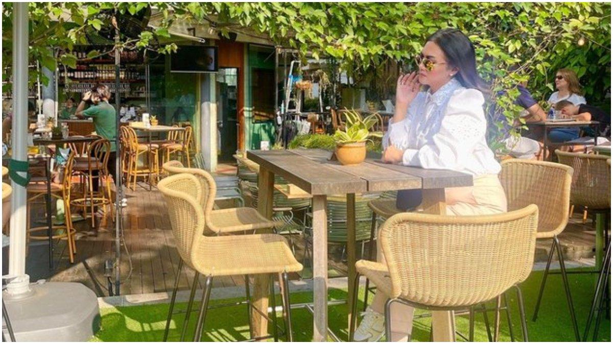 Bella Saphira tengah menikmati kopi di Singapura.