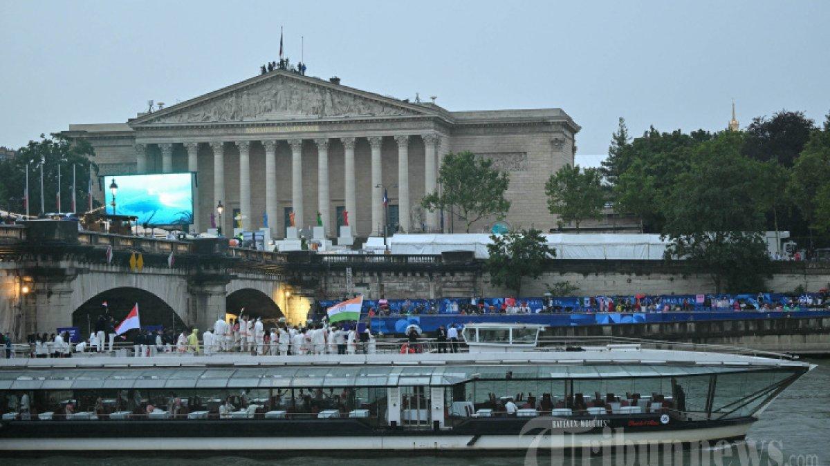 Delegasi dari Indonesia, india, dan Iran berlayar dengan perahu selama upacara pembukaan Olimpiade Paris 2024 di Paris pada tanggal 26 Juli 2024, dengan Palais Bourbon, gedung Majelis Nasional Prancis, terlihat di latar belakang.