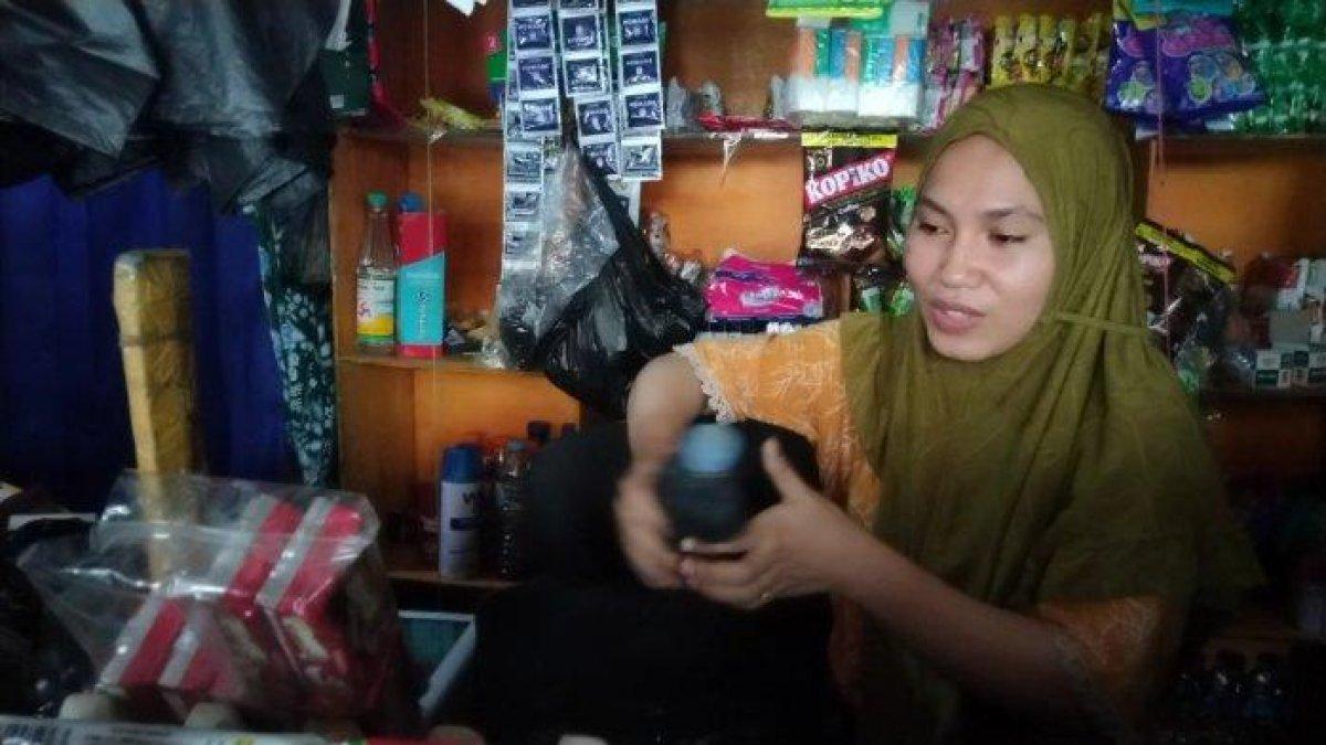 Desi (26) menunjukkan botol sambal saat menjaga toko kelontong usai viral lawan perampok bersenjata busur saat ditemui di tokonya Jl Urip Sumoharjo, Makassar, Kamis (26/11/2023) sore.