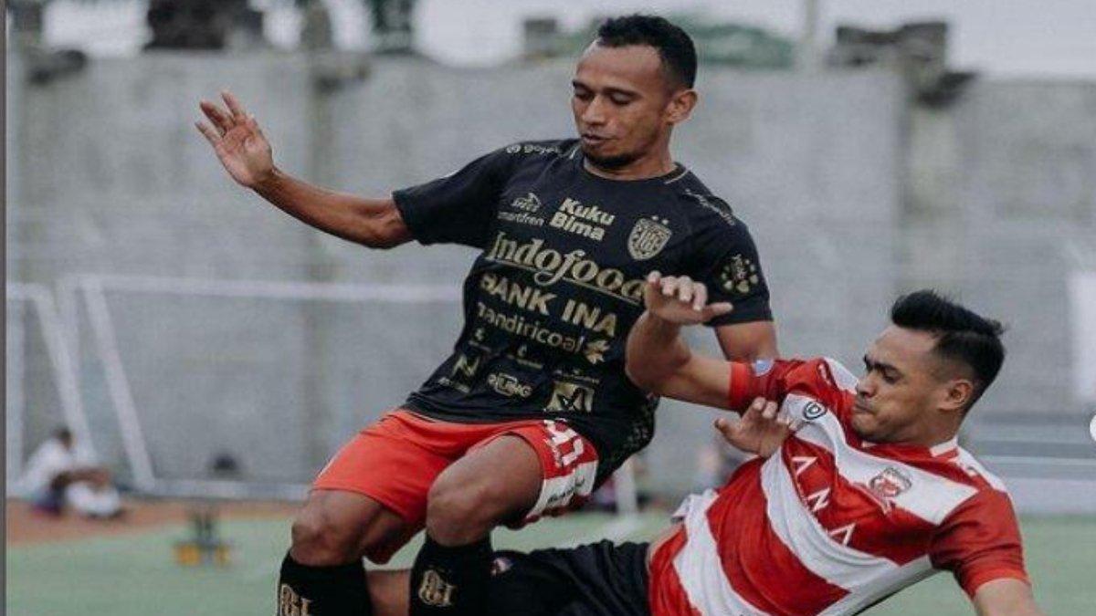 Duel pemain Bali United (kiri) dan pemain Madura United (kanan) dalam pertandingan Liga 1.