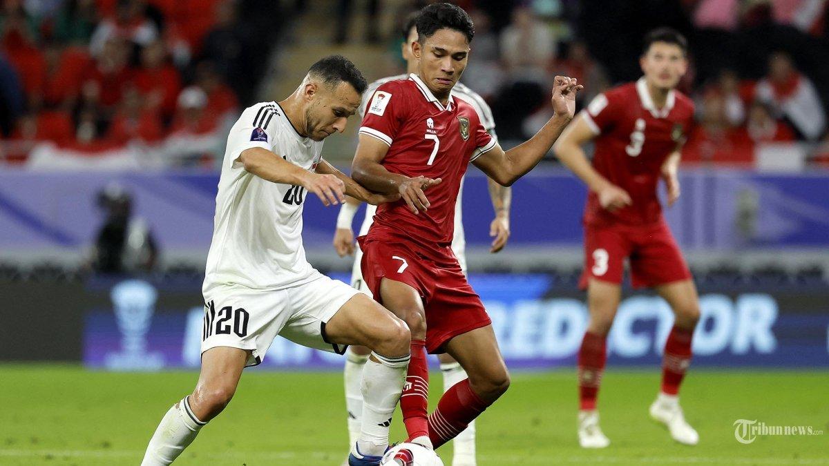 Gelandang Indonesia Marselino Ferdinan (7) berebut bola dengan gelandang Irak Osama Rashid (20) pada pertandingan sepak bola Grup D Piala Asia AFC Qatar 2023 antara Indonesia dan Irak di Stadion Ahmad bin Ali di Al-Rayyan, sebelah barat Doha. senin (15 Januari 2024). Timnas Indonesia gagal memetik poin dalam laga perdananya di Piala Asia 2023 setelah dicukur Irak dengan skor 3-1, Senin (15/1/2024).