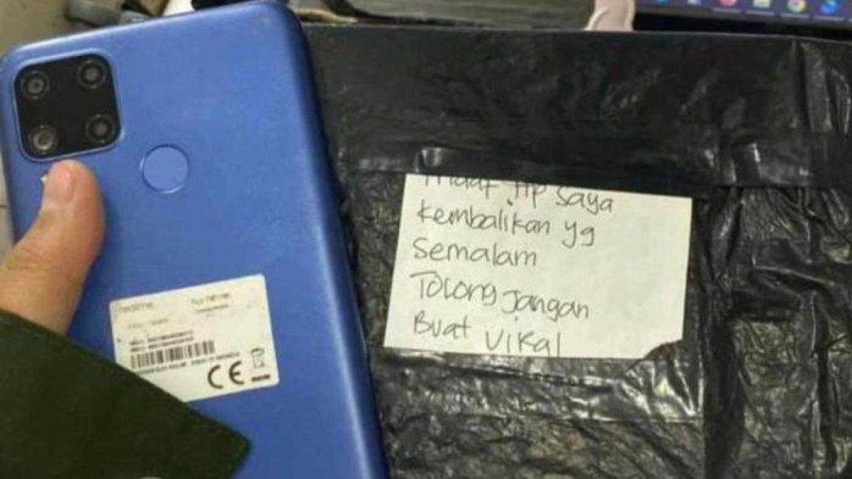 Handphone kurir ekspedisi dan secarik kertas pernyataan pen