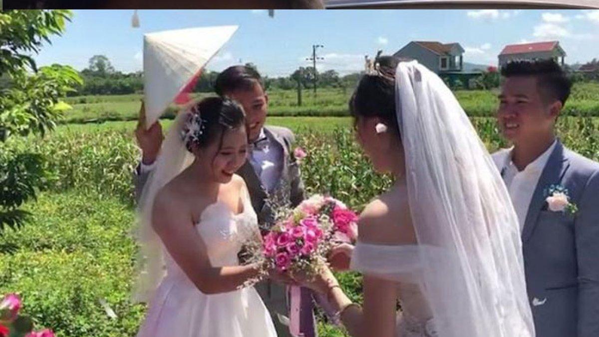 Ikut tradisi, pengantin wanita tersipu malu tukar buket bunga emas dengan mempelai lain (saostar.vn)