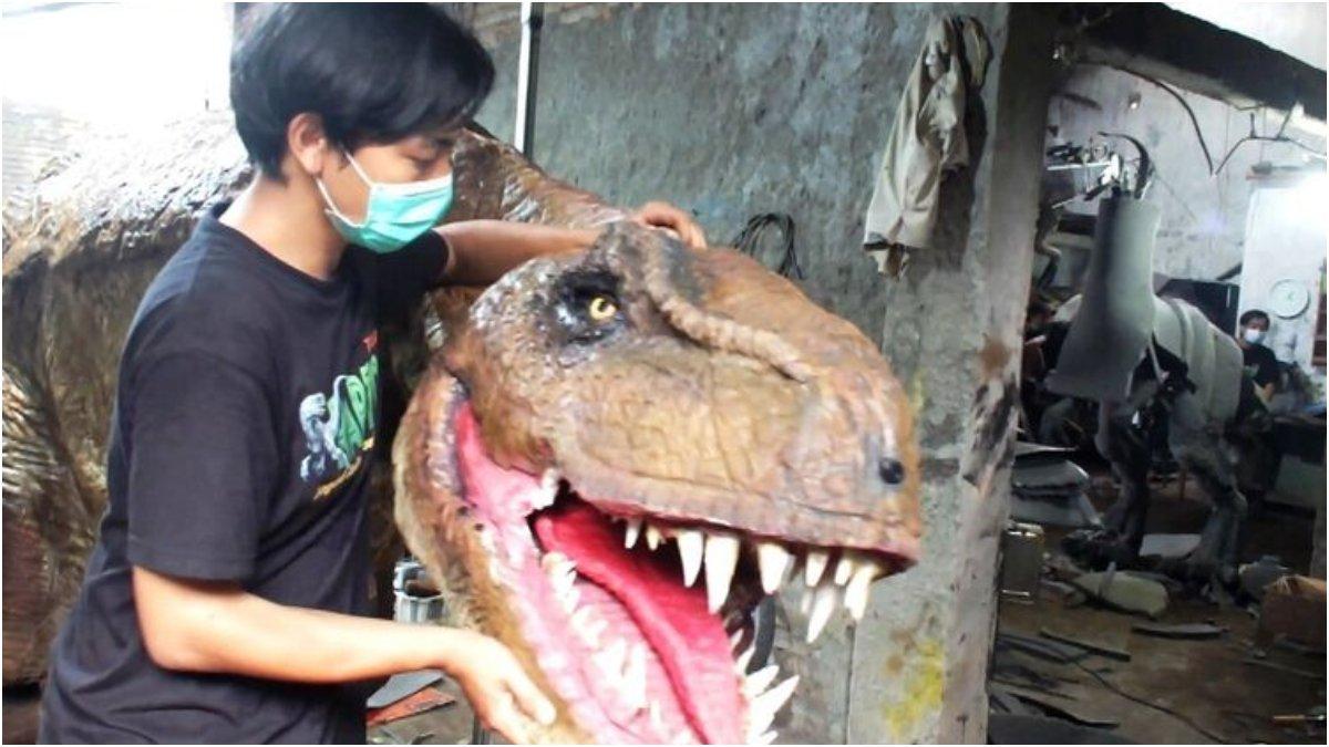 Iqbal Firmansyah Bersama Dinosaurus buatannya di Bengkel Jagad Adwork, Banguntapan, Bantul
