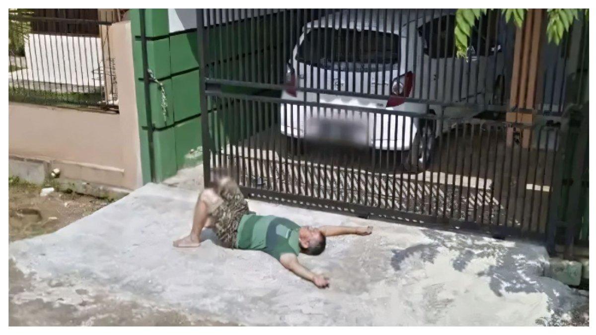 Bapak-bapak sedang berjemur di depan teras rumahnya