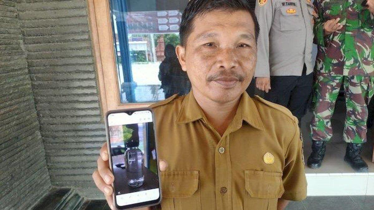 Kasi Pemerintahan Desa Cikalahang, Jaji Suraji saat menunjukkan botol miras yang diduga digunakan untuk pesta miras oplosan di Desa/Kecamatan Dukupuntang, Kabupaten Cirebon