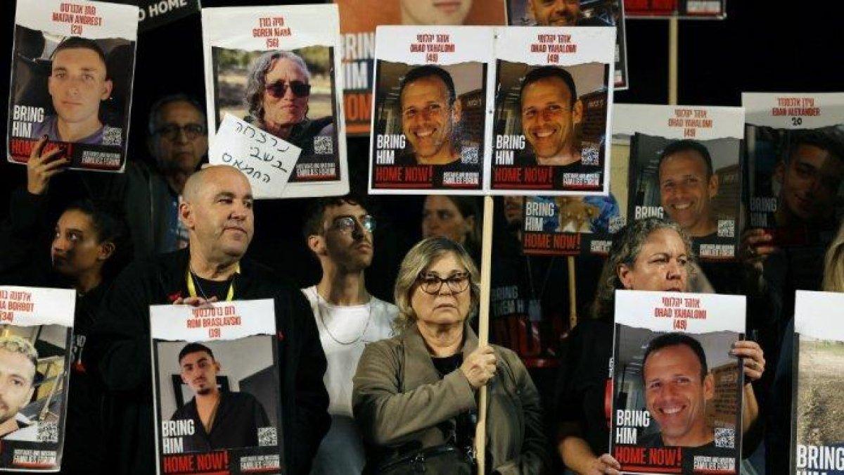 Kerabat dan pendukung memegang plakat bergambar sandera Israel yang ditahan di Gaza sejak serangan Hamas pada 7 Oktober di Israel selatan, dalam unjuk rasa yang menyerukan pembebasan mereka, di Tel Aviv pada 30 Desember 2023.
