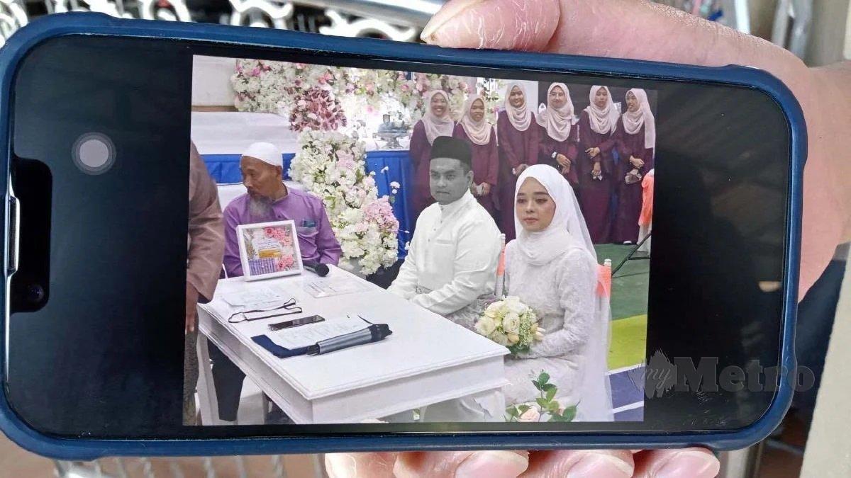 Kerabat menunjukkan foto pernikahan Aini dan Norsyam