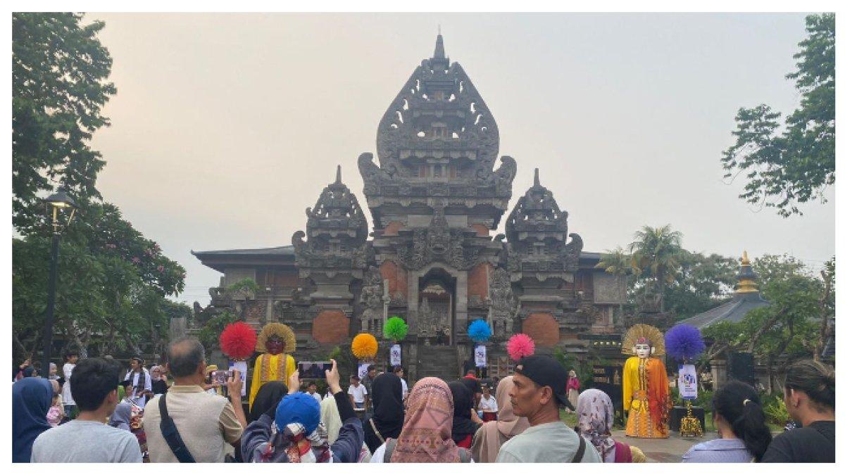 KERAMIAN  PENGUNJUNG - Keramaian pengunjung Taman Mini Indonesia Indah (TMII) yang memadati area Plaza Kori Agung, TMII, Jakarta Timur
