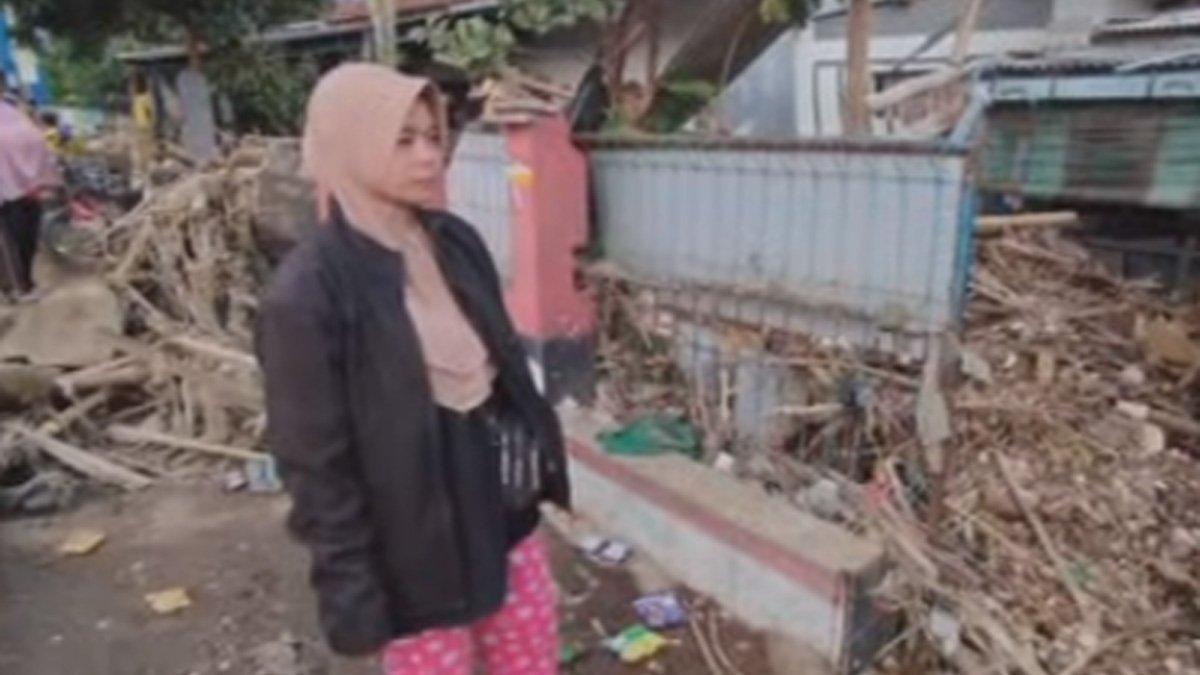 Kustini (40), warga Kampung Lamajang RT 01 cari motornya yang terbawa banjir.