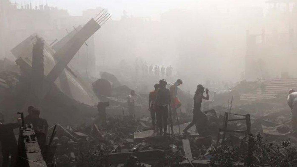 Warga Palestina mencari korban di atas puing-puing bangunan yang hancur usai pemboman Israel di Khan Younis, Jalur Gaza Selatan pada Jumat (27/10/23).