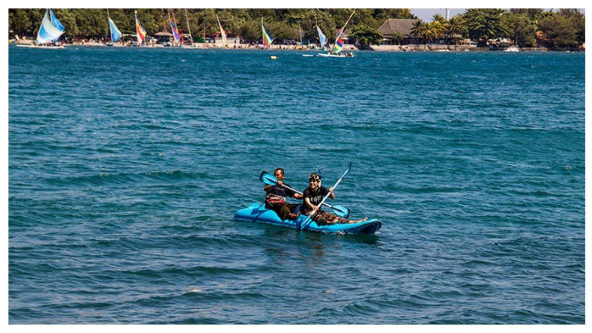 NAIK KANO di PANTAI PASIR PUTIH - Wisatawan tengah asyik menikmati sensasi naik kano di Pantai Pasir Putih Situbondo, merasakan keindahan alam sambil menikmati udara segar dan ombak yang tenang.