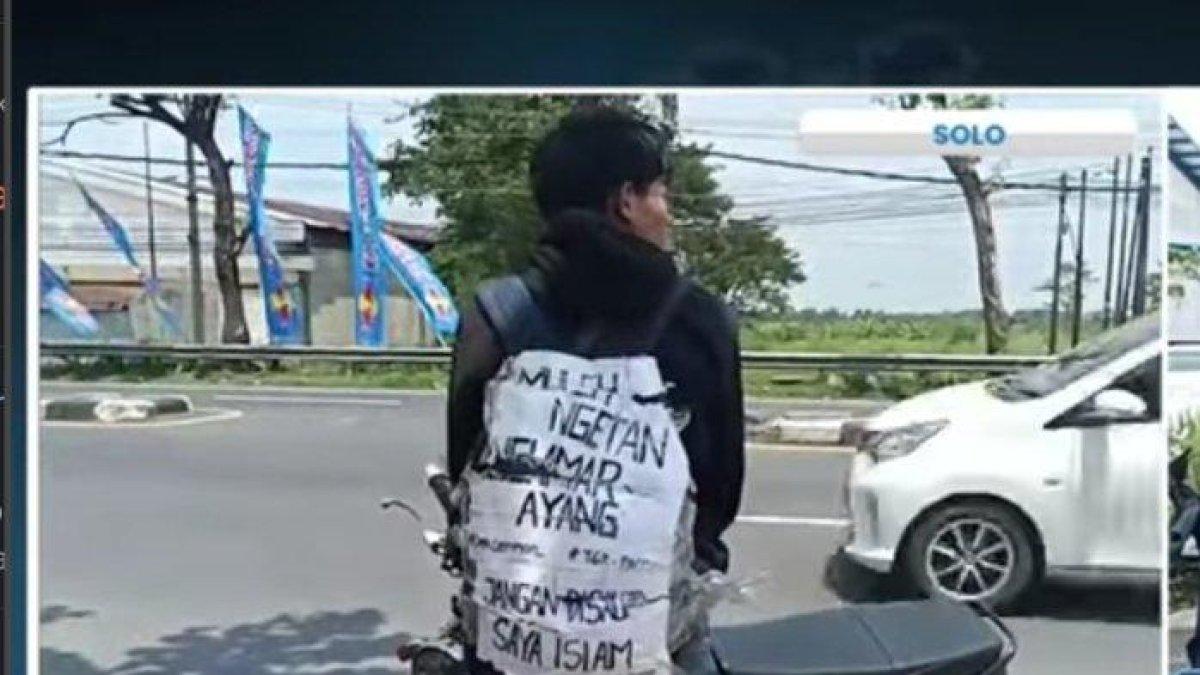 Pemudik sepeda motor yang menempelkan pesan di tasnya.