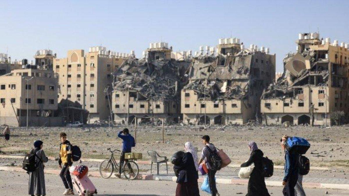 Penduduk kompleks perumahan Kota Hamad yang didanai Qatar di Khan Yunis di Jalur Gaza selatan, membawa beberapa barang milik mereka saat meninggalkan rumah setelah serangan Israel, pada 2 Desember 2023. Gencatan senjata sementara antara Israel dan Hamas berakhir pada 1 Desember 2023, dengan tentara Israel mengatakan operasi tempur telah dilanjutkan, menuduh Hamas melanggar jeda operasional.