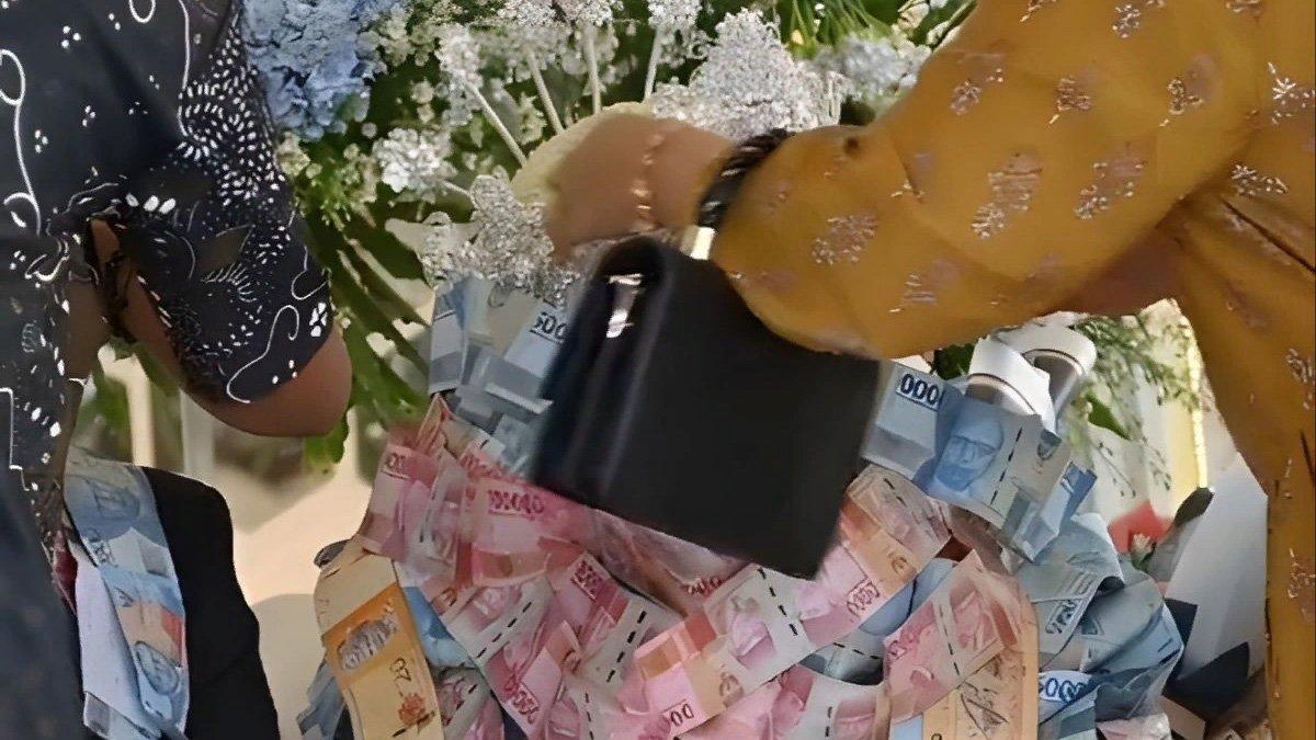 Pengantin di Madura kewalahan terima hadiah kalung uang dari tamu undangan.