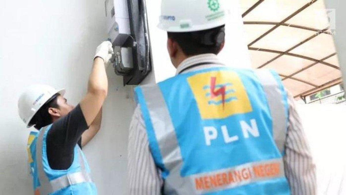 Petugas PLN mengecek meteran listrik warga