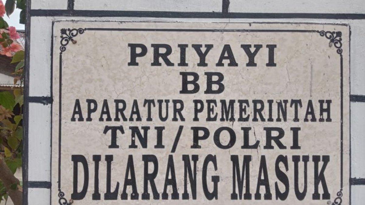 Plakat larangan masuknya pegawai yang terpasang di gapura masuk Dusun Setono, Desa Tales, Kecamatan Ngadiluwih.