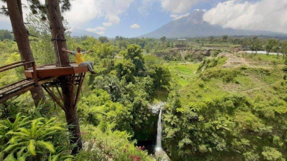 WISATA AIR TERJUN - Potret Wisatawan berfoto di atas spot foto di atas Air Terjun Kedung Kayang disadur dari TribunJogja.com, Minggu (2/3/2025). Air Terjun Kedung Kayang menawarkan pemandangan yang asri.