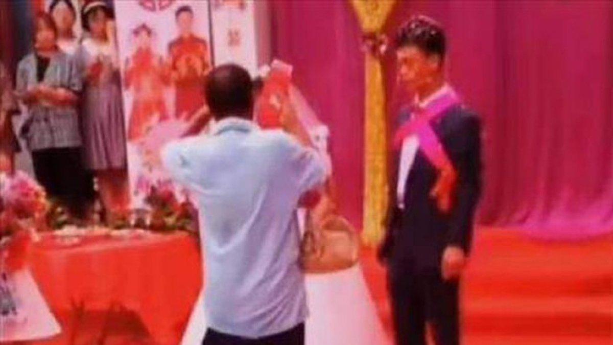Pria paruh baya berpakaian kaus dengan celana pendek itu menghampiri kedua mempelai dan memberikan hadiah, siapa dia?