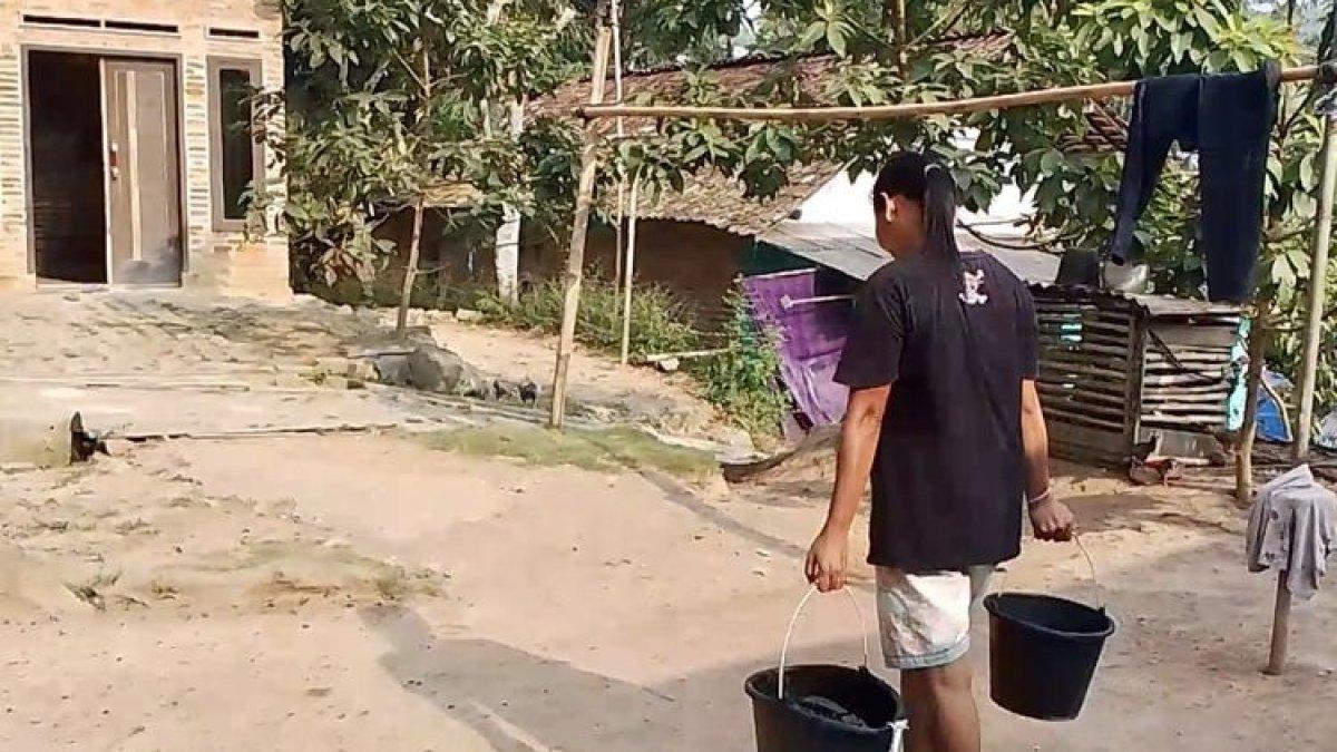 Salah satu warga LK 1, Kelurahan Way Laga membawa air dari penampungan kolektif, Jumat (8/9/2023).