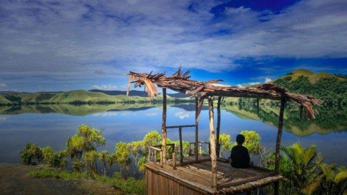 Salah satu warga, saat duduk di sebuah bukit sambil memandang ke arah Danau Sentani di Tanjung Cinta, Kampung Doyo Lama, Distrik Waibu, Kabupaten Jayapura, Papua.