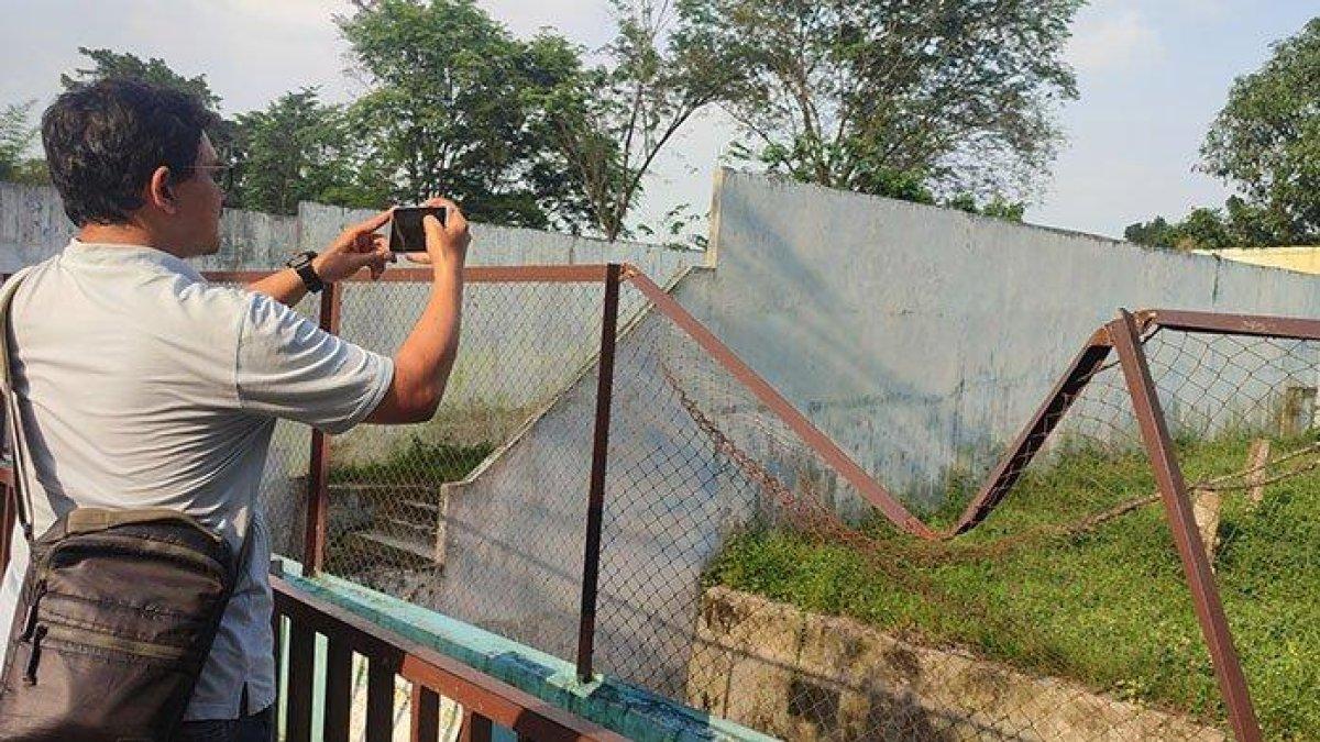 Seorang pengunjung mengabadikan kondisi salah satu kandang hewan di Medan Zoo