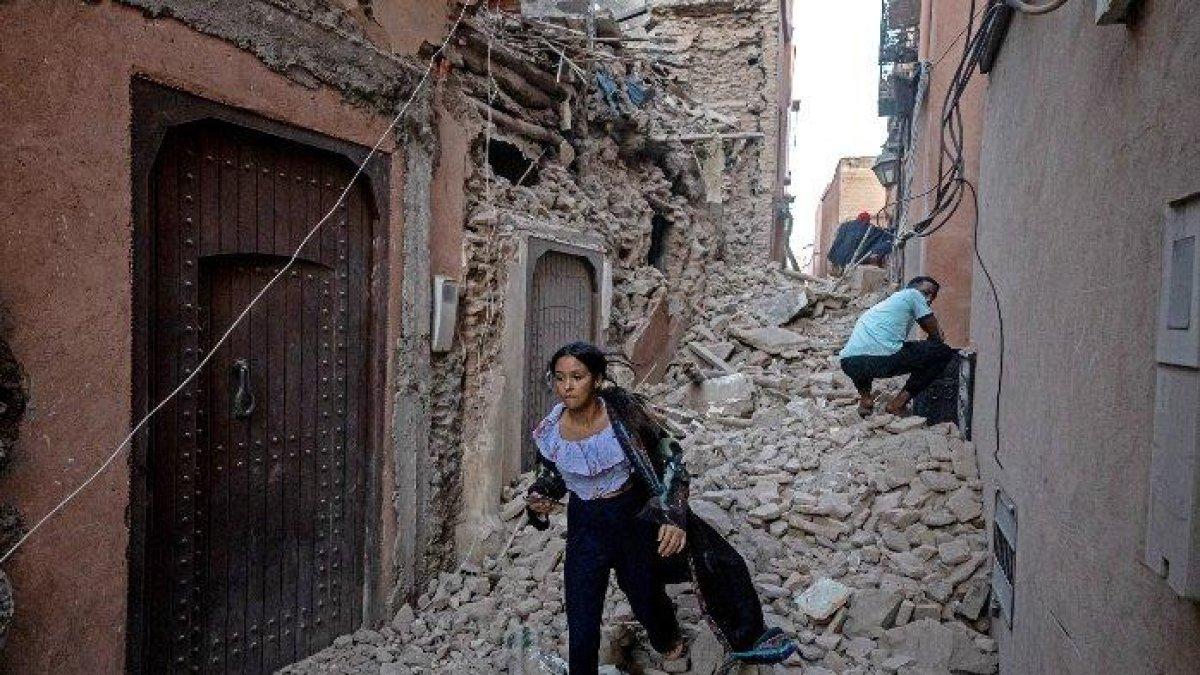 Seorang wanita mengungsi bersama barang-barangnya melalui reruntuhan di kota tua Marrakesh yang rusak akibat gempa pada 9 September 2023. Gempa bumi dahsyat yang mengguncang Maroko pada akhir 8 September menewaskan lebih dari 632 orang, menurut angka kementerian dalam negeri, membuat penduduk yang ketakutan meninggalkan rumah mereka di tengah malam.