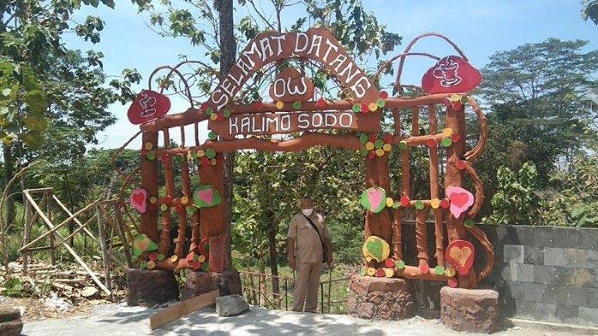 Seorang warga berfoto di gapura kedatangan objek wisata Kalimosodo, Desa Sudimoro, Kecamatan Tulung, Kabupaten Klaten, Jawa Tengah, Senin (6/9/2021).