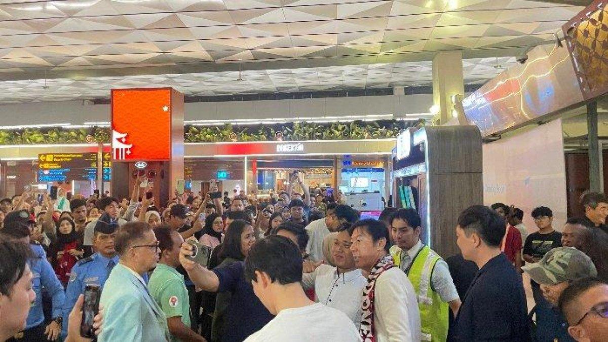 Para pendukung Timnas Indonesia berswafoto dengan mantan Pelatih Timnas Indonesia, Shin Tae-yong, di Bandara Soekarno-Hatta, Tangerang, Banten, Minggu (26/1/2025)