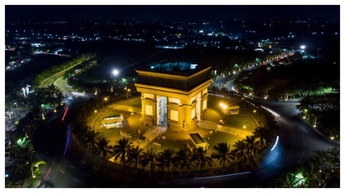 SIMPANG GUMUL KEDIRI - Simpang Gumul Kediri pada malam hari tampak megah dengan pencahayaan indah yang menyorot bangunan ikonik mirip Arc de Triomphe. Suasana makin romantis dan Instagramable, cocok buat jalan santai, foto malam hari, atau sekadar nongkrong.