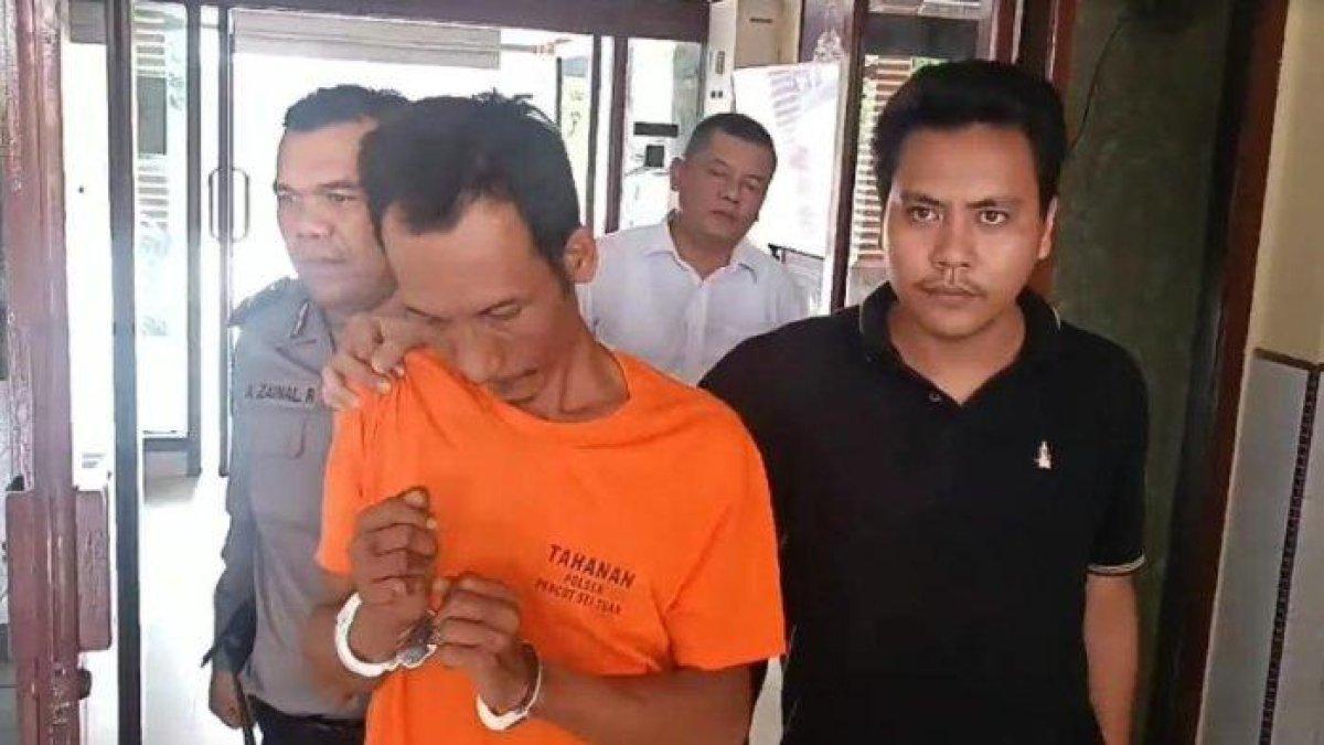 Tampang Sulaiman Purba, pelaku pembakaran wanita pemilik rumah makan bernama Herlinda Gurusinga, saat digiring oleh petugas memasuki sel tahanan di Polsek Medan Tembung, Senin (20/5/2024).