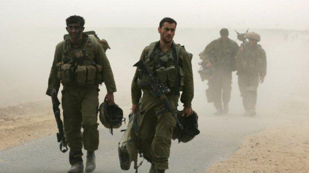 Tentara Israel dari unit infanteri Golani berjalan keluar dari Jalur Gaza Palestina dekat Kibbutz Ein Hashlosha selama badai pasir setelah operasi di dalam Gaza, 17 Oktober 2007.